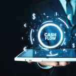 Man holding Cash Flow words with currency symbols. Finance concept